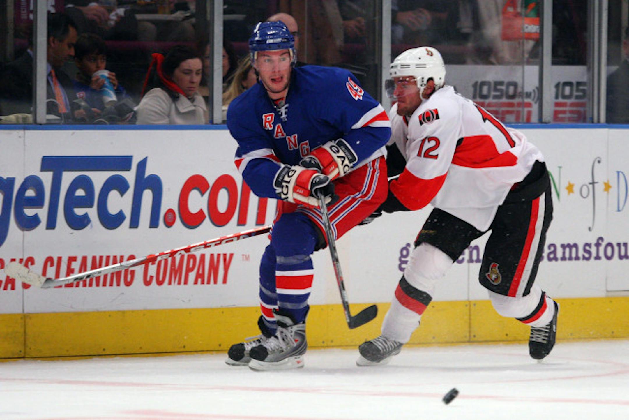 NEW YORK - NOVEMBER 17: Dan Fritsche #49 of the New York Rangers clears the puck from Mike Fisher #12 of the Ottawa Senators on November 17, 2008 at Madison Square Garden in New York City.