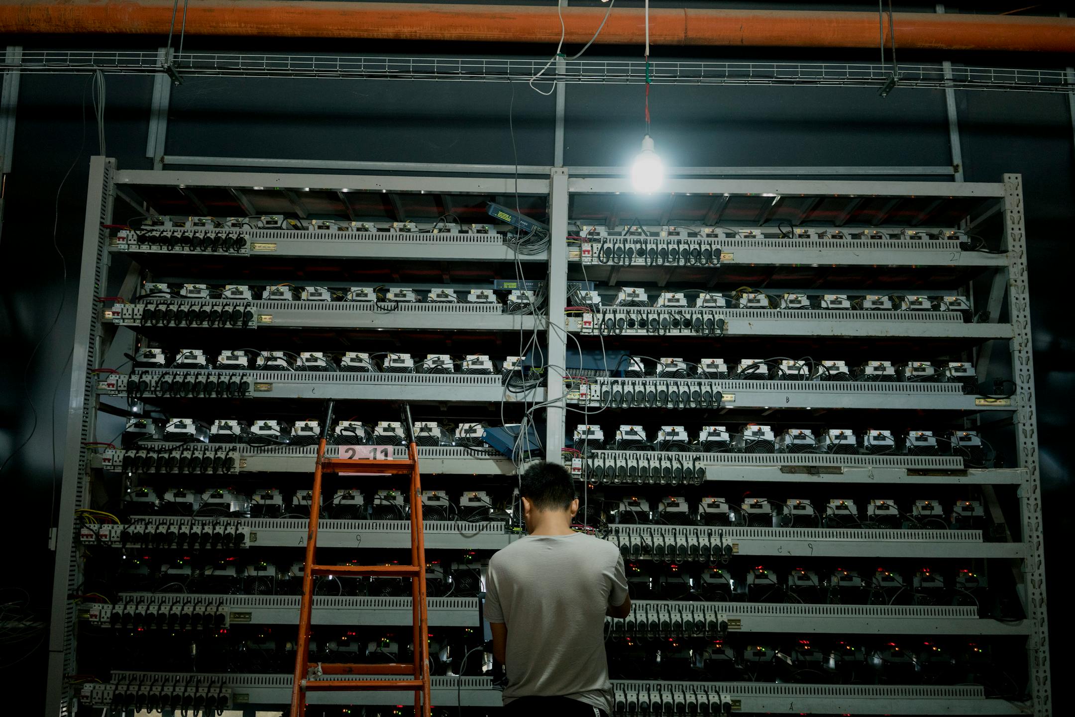 Li Shuangsheng, works at Bitmain, a Bitcoin farm in Dalad Banner, Mongolia, Aug. 11, 2017. According to an estimate backed up by independent researchers, the creation of an average NFT has a stunning environmental footprint of more than 200 kilograms of planet-warming carbon, equivalent to driving 500 miles in a typical American gasoline-powered car.