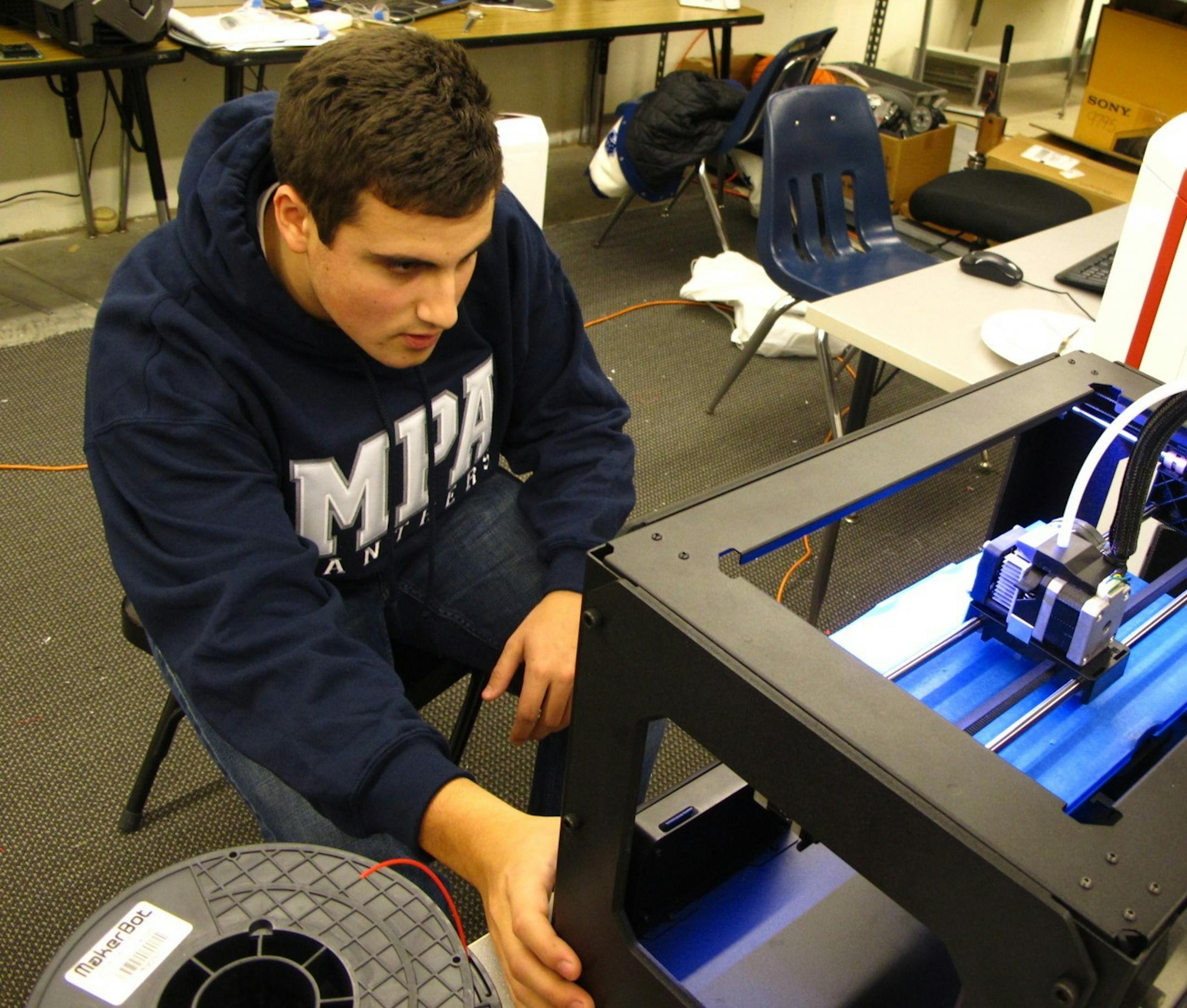Mounds Park Academy senior Brendan Boyle demonstrates the use of a 3D printer in the schoolís new digital fabrication lab, which he helped launch.