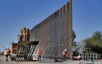 FILE - In this Sept. 10, 2019 file photo, government contractors erect a section of Pentagon-funded border wall along the Colorado River in Yuma, Ariz