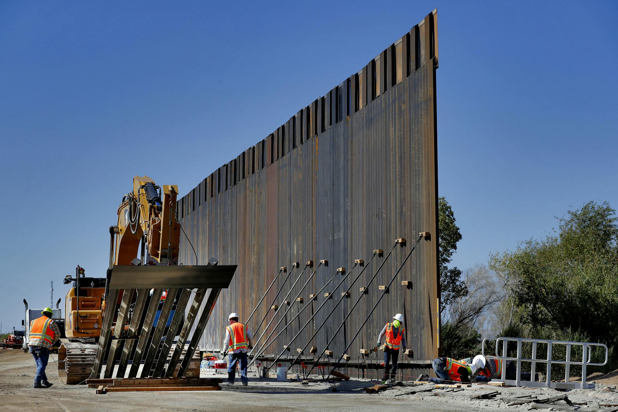 FILE - In this Sept. 10, 2019 file photo, government contractors erect a section of Pentagon-funded border wall along the Colorado River in Yuma, Ariz. Defense officials say the Department of Homeland Security has asked the Pentagon to fund the construction of 270 miles of border wall this year as part of a counter-drug effort. (AP Photo/Matt York)