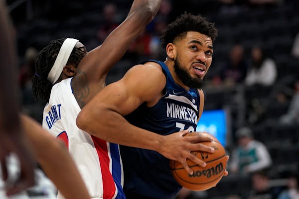 Minnesota Timberwolves center Karl-Anthony Towns (32) drives on Detroit Pistons forward Jerami Grant (9) in the first half of an NBA basketball game i
