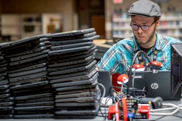 Dylan Feddersen, cq, from the IT staff at Big Lake High School, worked on prepping hundreds of laptops for students at Big Lake High School, Monday, A