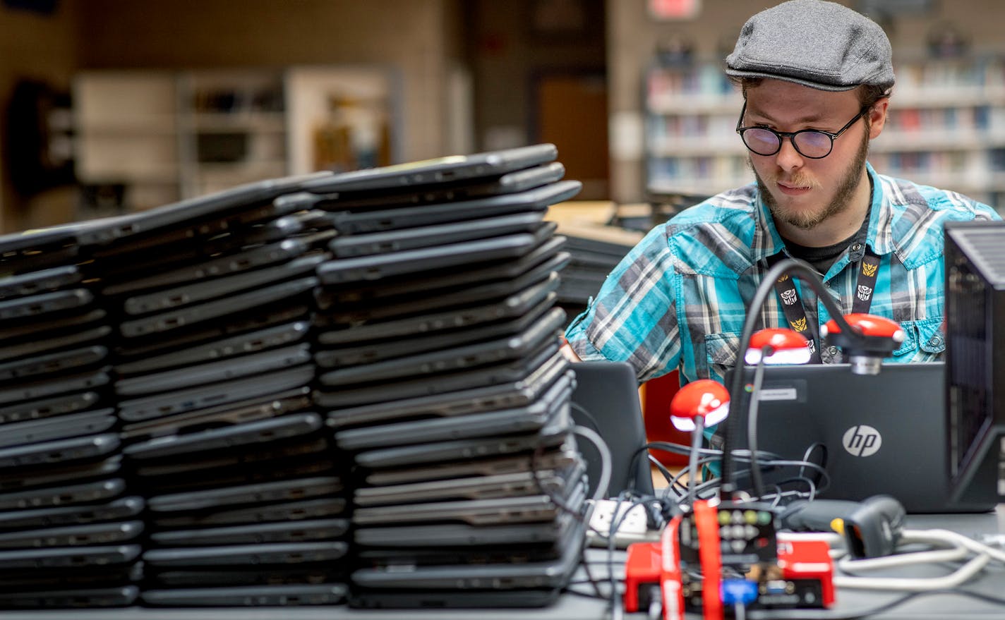 Dylan Feddersen, cq, from the IT staff at Big Lake High School, worked on prepping hundreds of laptops for students at Big Lake High School, Monday, August 2, 2021 in Big Lake, MN. ] ELIZABETH FLORES • liz.flores@startribune.com