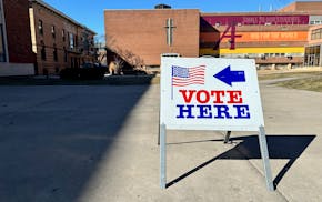 A sign bearing an American flag that says "vote here."