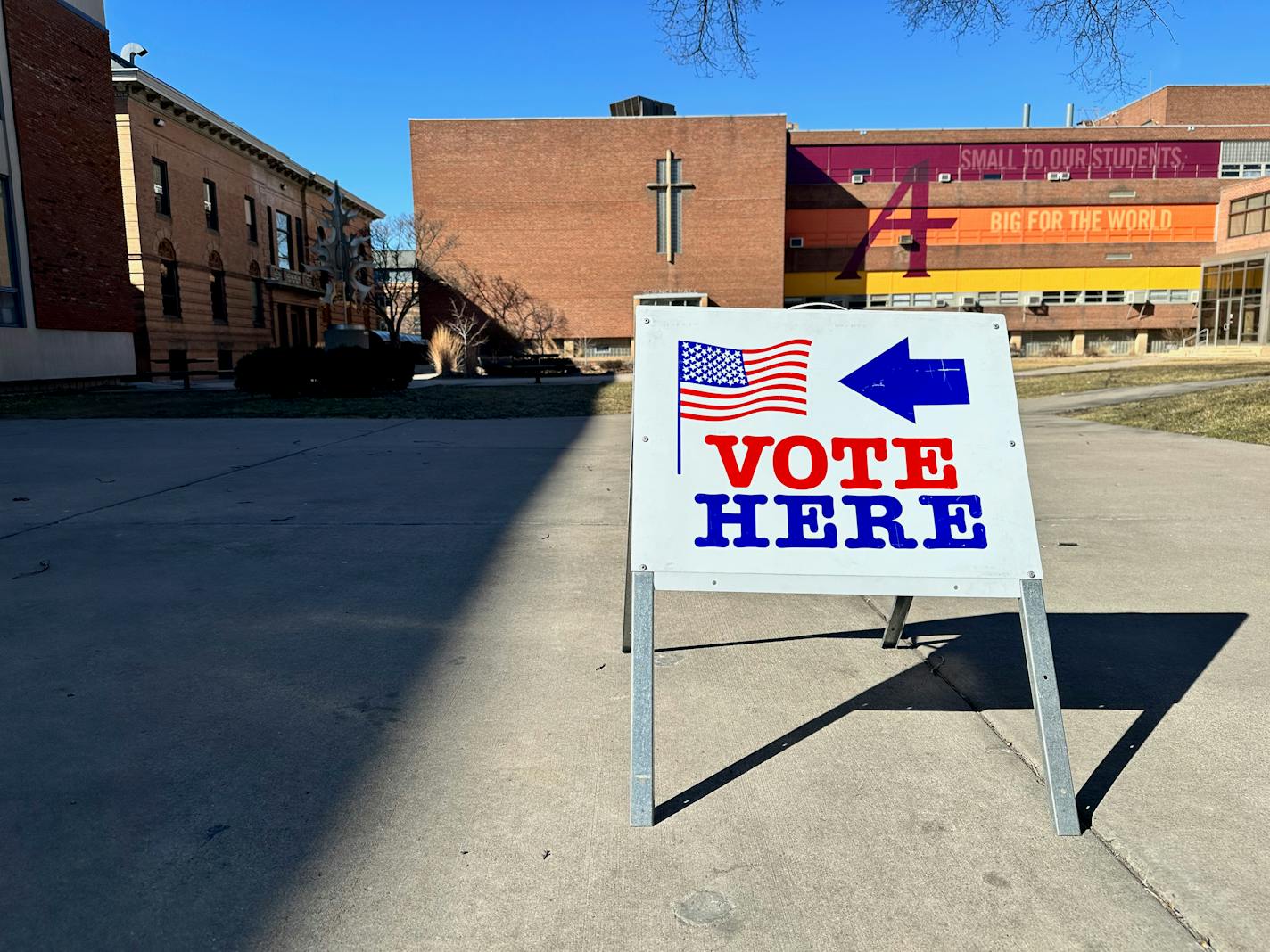 A sign bearing an American flag that says "vote here."