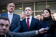 Trooper Ryan Londregan, center, stood with his wife as they were surrounded by security, his lawyers and dozens of supporters as his lawyer spoke to m