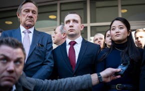 Trooper Ryan Londregan, center in maroon tie, stood hand-in-hand with his wife surrounded by security, his lawyers and dozens of supporters, including