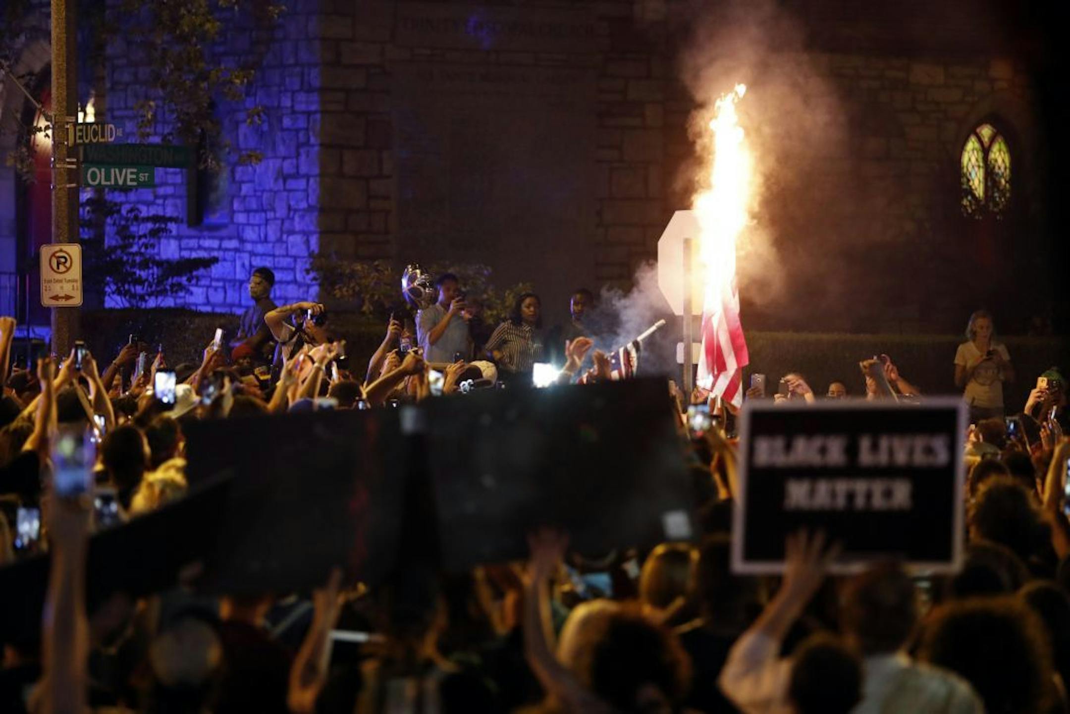 A flag is set on fire as protesters gather, Friday, Sept. 15, 2017, in St. Louis, after a judge found a white former St. Louis police officer, Jason Stockley, not guilty of first-degree murder in the death of a black man, Anthony Lamar Smith, who was fatally shot following a high-speed chase in 2011.