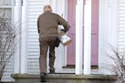 A UPS man delivers a package to a residence last week in North Andover, Mass. Today is Cyber Monday, when most online retailers offer deals.