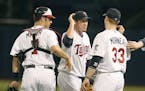 Justin Morneau congratulated Joe Nathan after a game in 2009. The catcher is Joe Mauer.