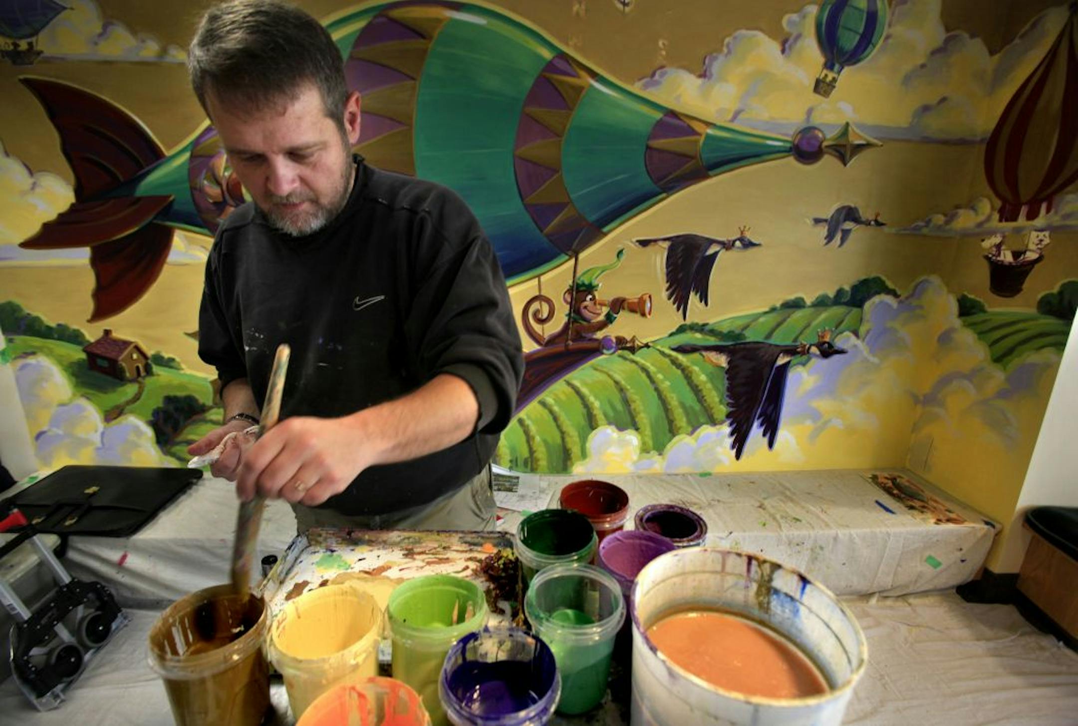 Artist Greg Preslicka is painting a new mural in the children's area of the Savage Public Library. The mural is titled "Take Flight" and illustrates the learning and imagination that takes place in books.Savage, MN on January 22, 2013.