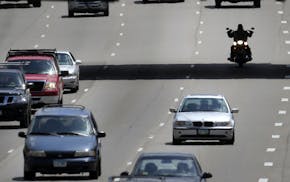 Seen from the 40th Street pedestrian bridge, a motorcylcist is sihlouetted beneath the 42nd Street Bridge while traveling north along I-35W, Friday, J