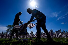 Volunteers help put up a field of flags near the War Memorial May 23 in Milwaukee.