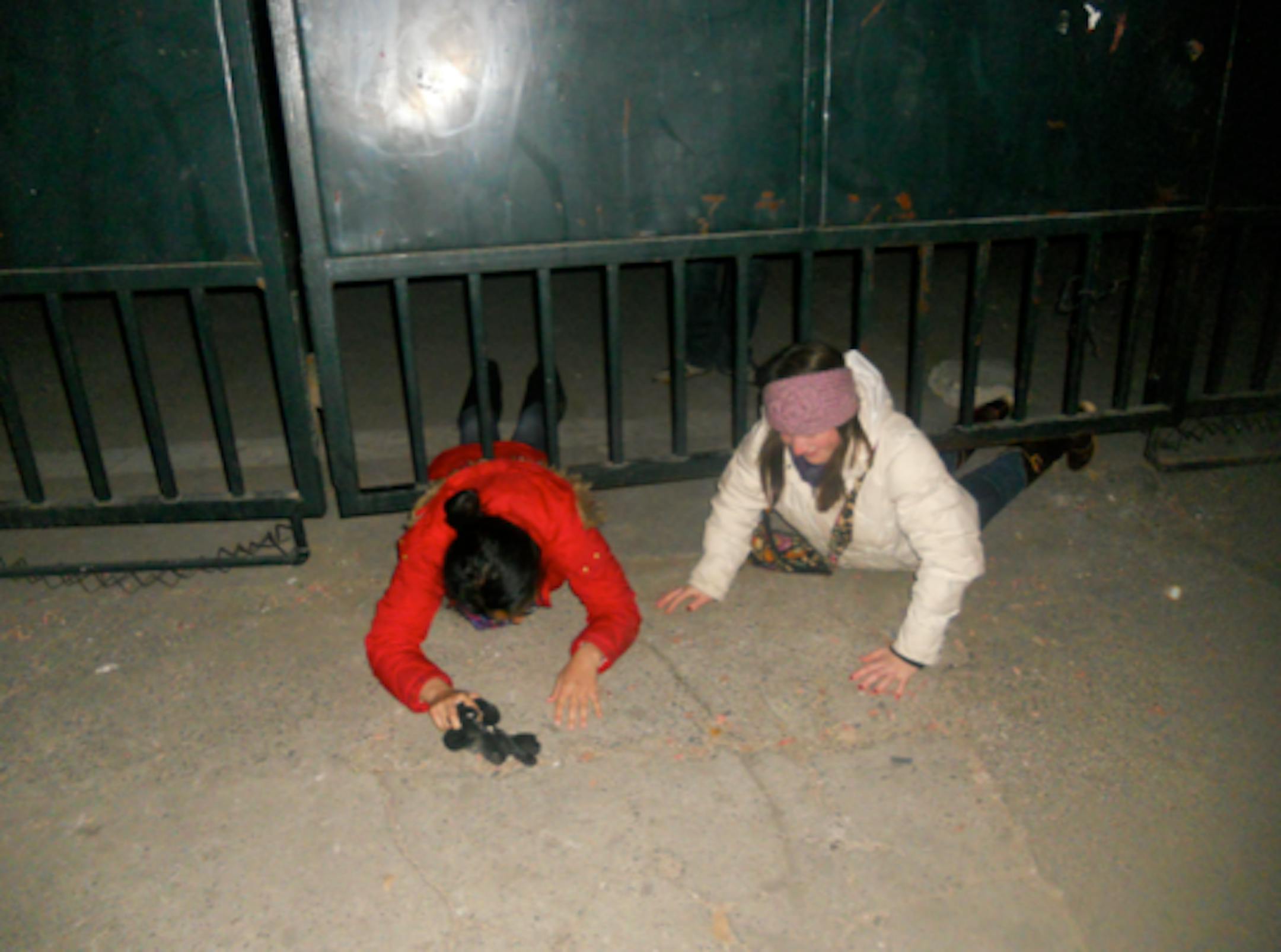 Izzi and Jess being super spies as they slide underneath North Gate.