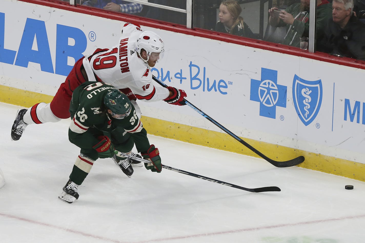 Carolina Hurricanes' Dougie Hamilton reaches for the puck over Minnesota Wild's Mats Zuccarello in the first period of an NHL hockey game Saturday, Nov. 16, 2019, in St. Paul, Minn. (AP Photo/Stacy Bengs)