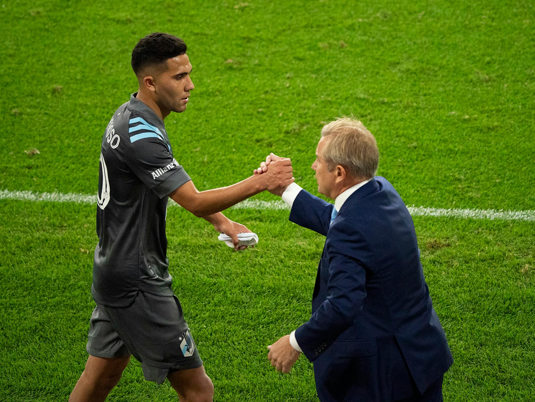 Minnesota United midfielder Emanuel Reynoso (10) was greeted by head coach Adrian Heath as he came off the pitch in the second half.