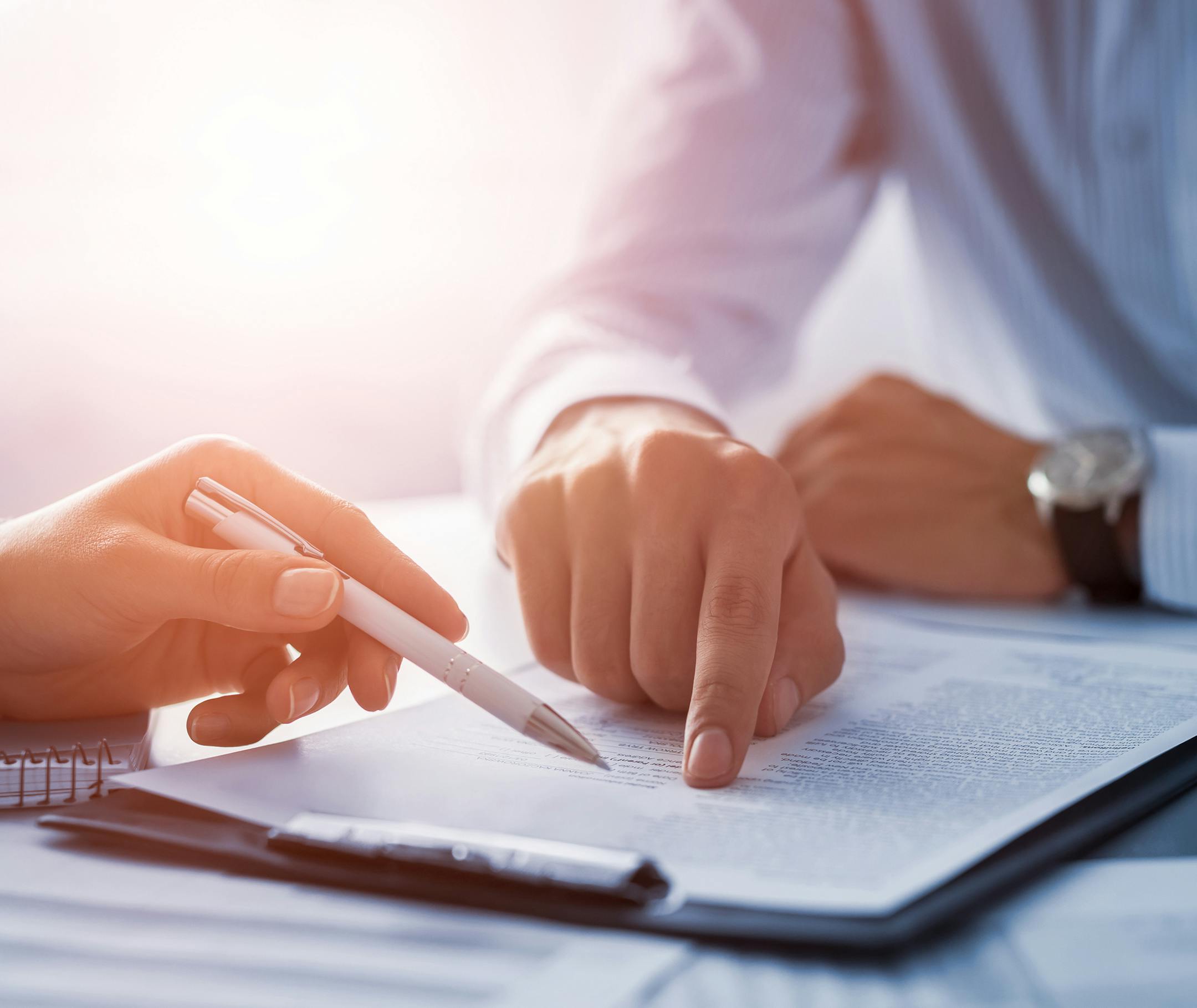 Business people negotiating a contract. Human hands working with documents at desk and signing contract.