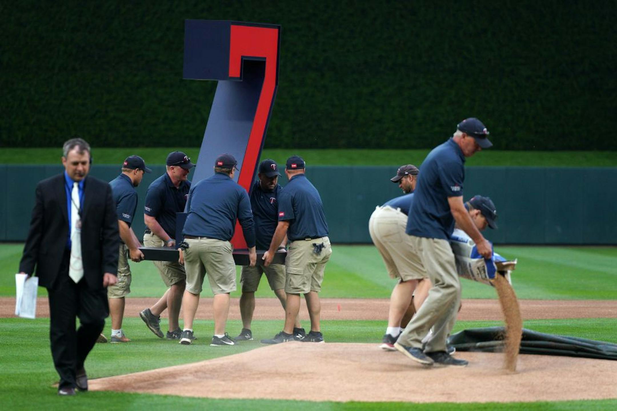 Grounds crew moved a massive number 7 into place before a pregame ceremony to retire Twins great Joe Mauer's number 7 Saturday.