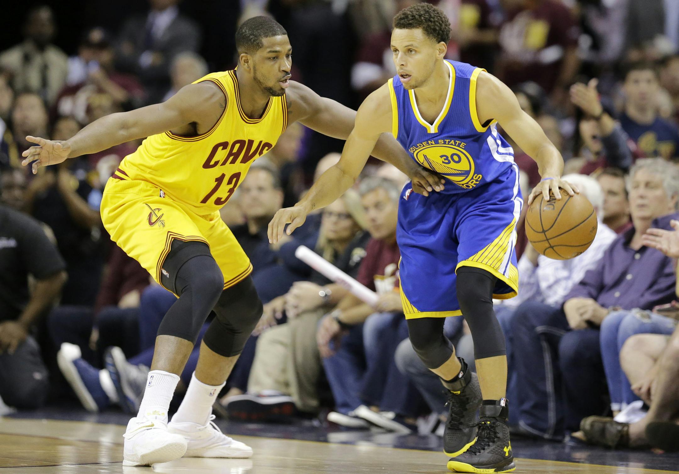 Cleveland Cavaliers center Tristan Thompson (13) defends Golden State Warriors guard Stephen Curry (30) during the first half of Game 3 of basketball's NBA Finals in Cleveland, Tuesday, June 9, 2015. (AP Photo/Tony Dejak)