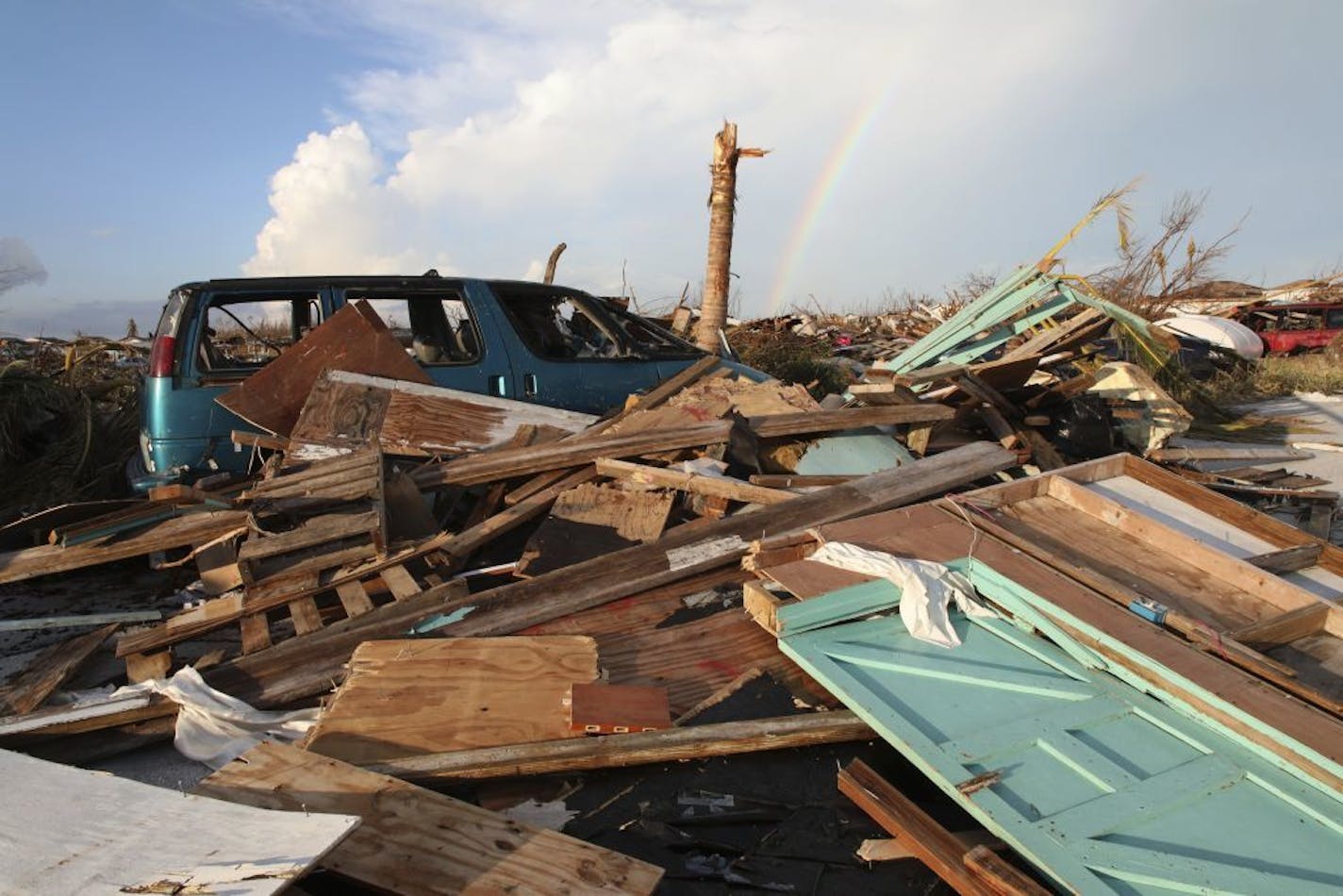 A rainbow rises over the extensive damage and destruction in the aftermath of Hurricane Dorian in The Mudd, Great Abaco, Bahamas, Thursday, Sept. 5, 2019. The Mudd was built by thousands of Haitian migrants over decades. It was razed in a matter of hours by Dorian, which reduced it to piles of splintered plywood and two-by-fours 4 and 5 feet deep, spread over an area equal to several football fields.