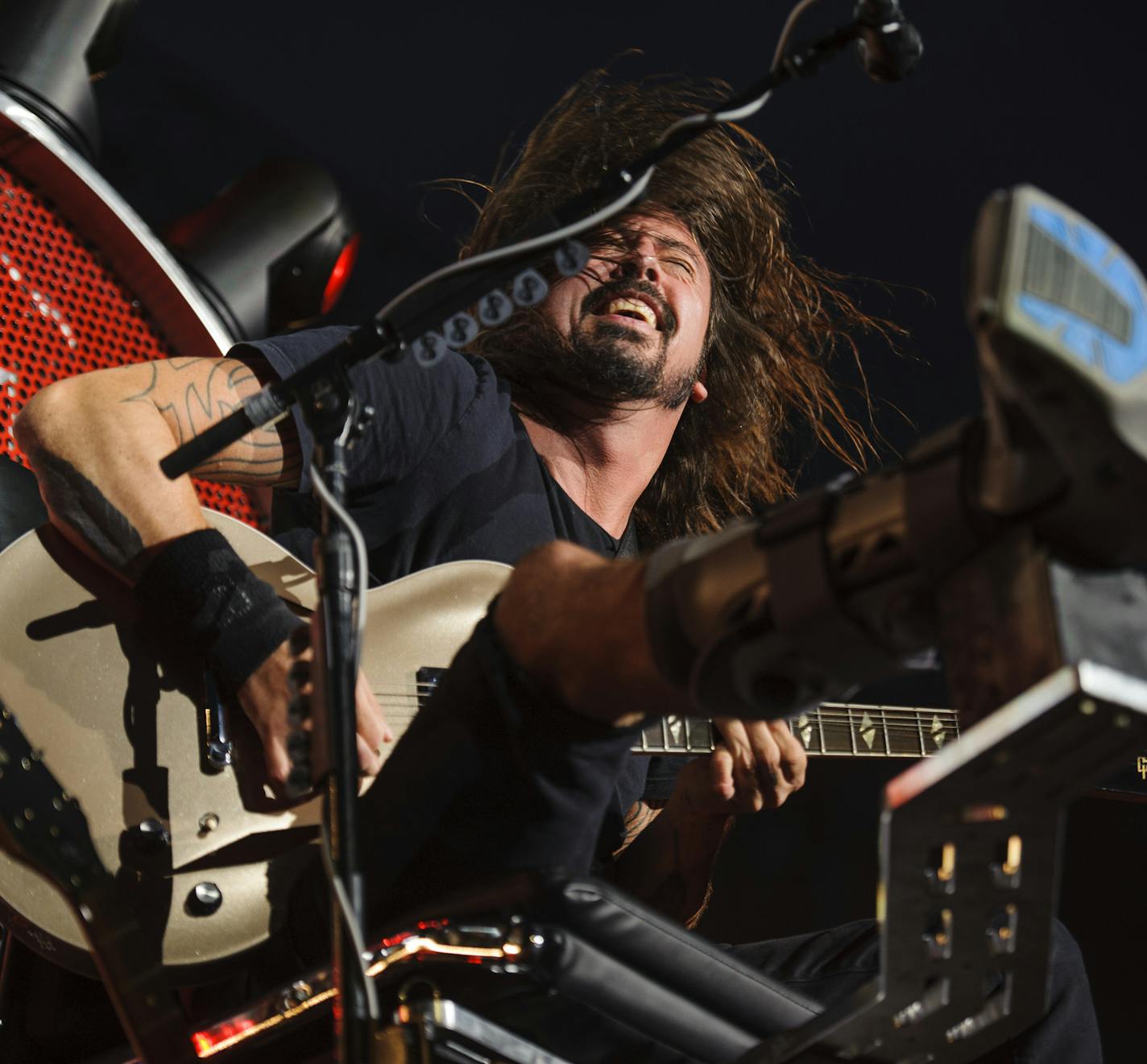 Dave Grohl, outfitted with a chair to accommodate a broken leg, performs with the Foo Fighters at Citi Field in New York, July 15, 2015. Grohl broke a bone in his leg last month while performing in Sweden. (Jacob Blickenstaff/The New York Times)