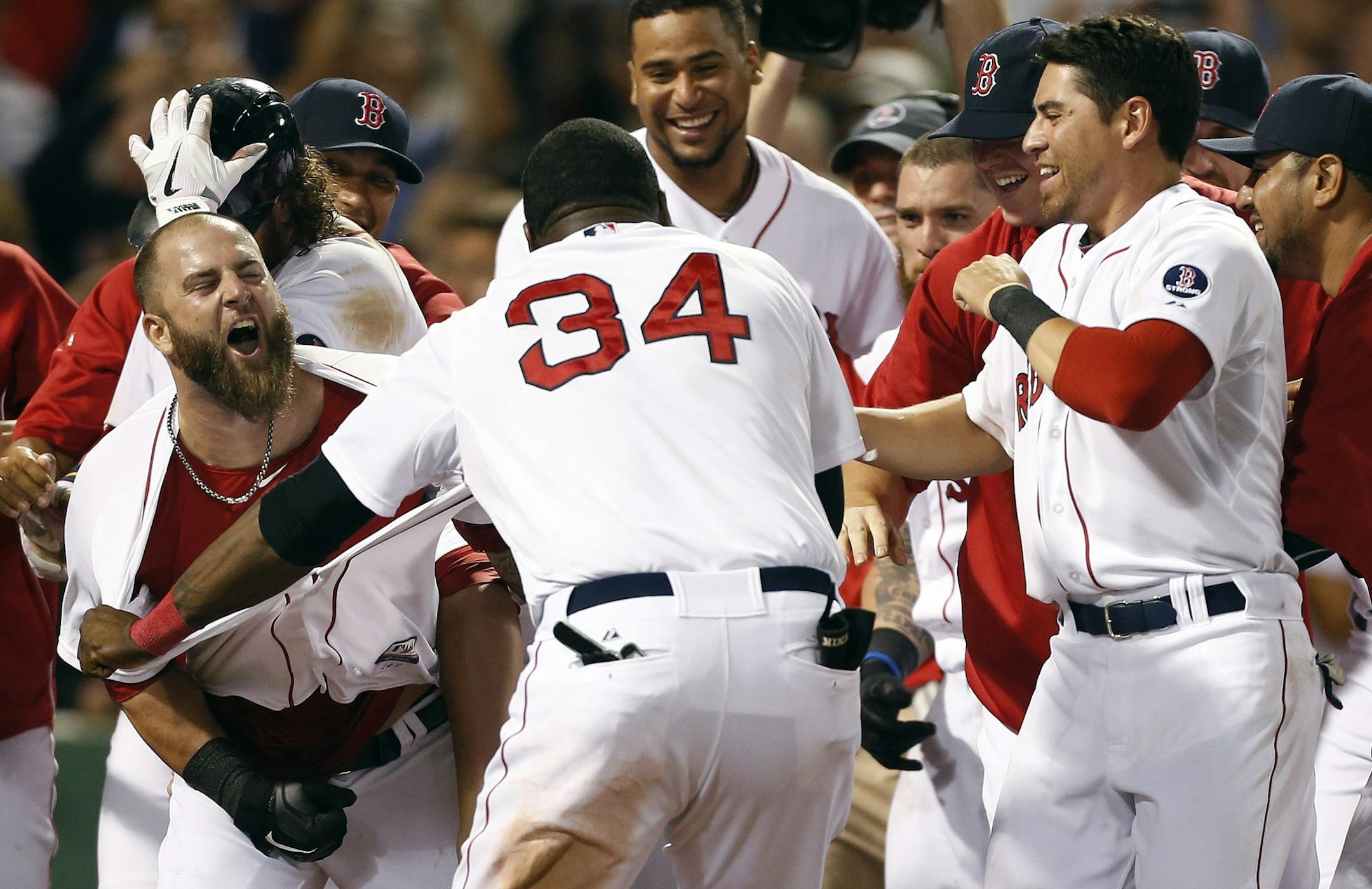 Boston Red Sox's Mike Napoli, left, celebrates his walk-off home run in the 11th inning of a baseball game against the New York Yankees in Boston, early Monday, July 22, 2013. The Red Sox won 8-7. (AP Photo/Michael Dwyer)