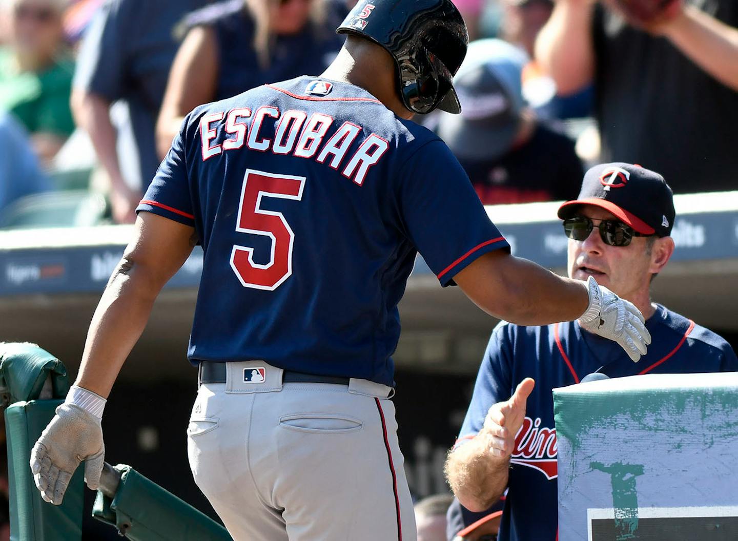 Minnesota Twins' Eduardo Escobar (5) is congratulated by manager Paul Molitor (4) after hitting a three-run home run during the sixth inning of a baseball game against the Detroit Tigers, Sunday, Sept. 24, 2017, in Detroit.