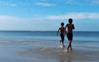 Of this photo taken at Fort Meyers Beach, Fla., Sharon Martin Kotula writes: "Brothers through adoption -- running into their new life together."