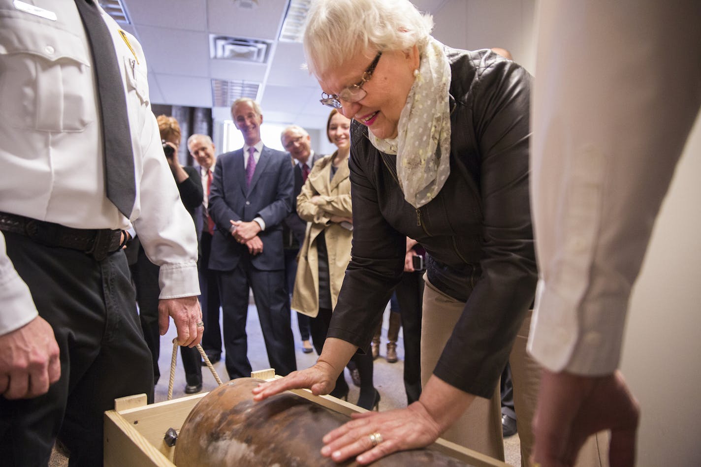 Janahne McCready-Johnson touches the Star Tribune Century Vault during a ceremony to remove and relocate the vault at the old Star Building in Minneapolis on Friday, April 24, 2015. ] LEILA NAVIDI leila.navidi@startribune.com / BACKGROUND INFORMATION: The vault was buried in 1948 and McCready-Johnson, then five-years-old and part of the representative Upper-Midwest family who's pictures of daily life were buried in the vault, was present at that ceremony. The vault will be relocated to the Star