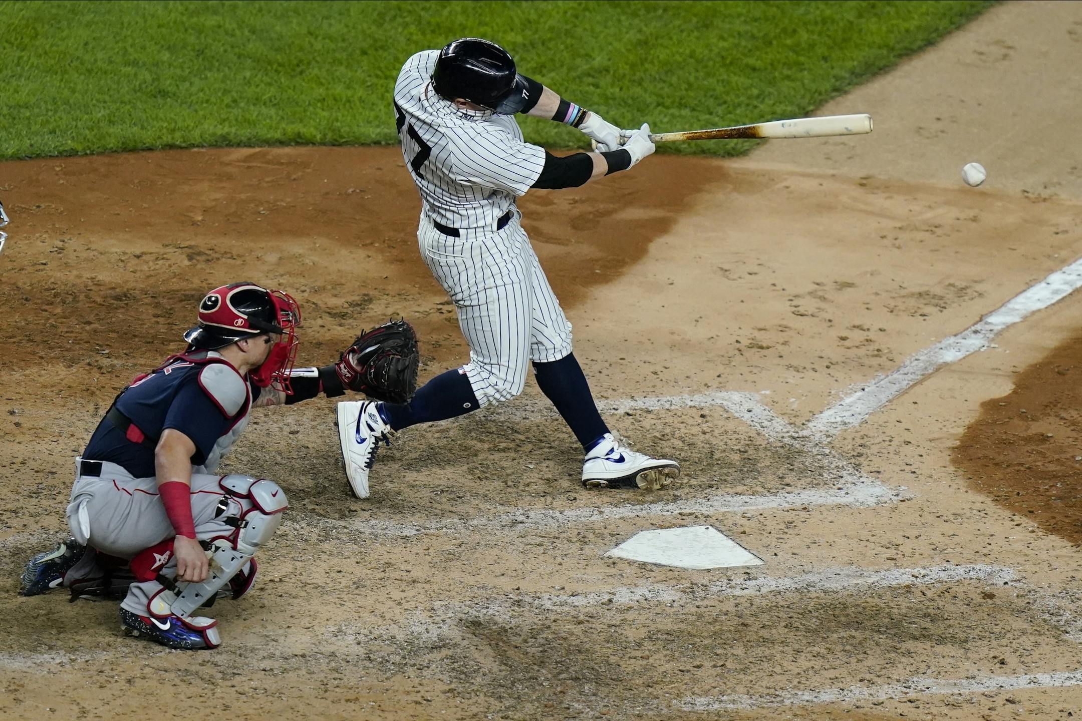 New York Yankees' Clint Frazier (77) hits a two-run double as Boston Red Sox catcher Christian Vazquez watches during the seventh inning of a baseball game Friday, Aug. 14, 2020, in New York. (AP Photo/Frank Franklin II)
