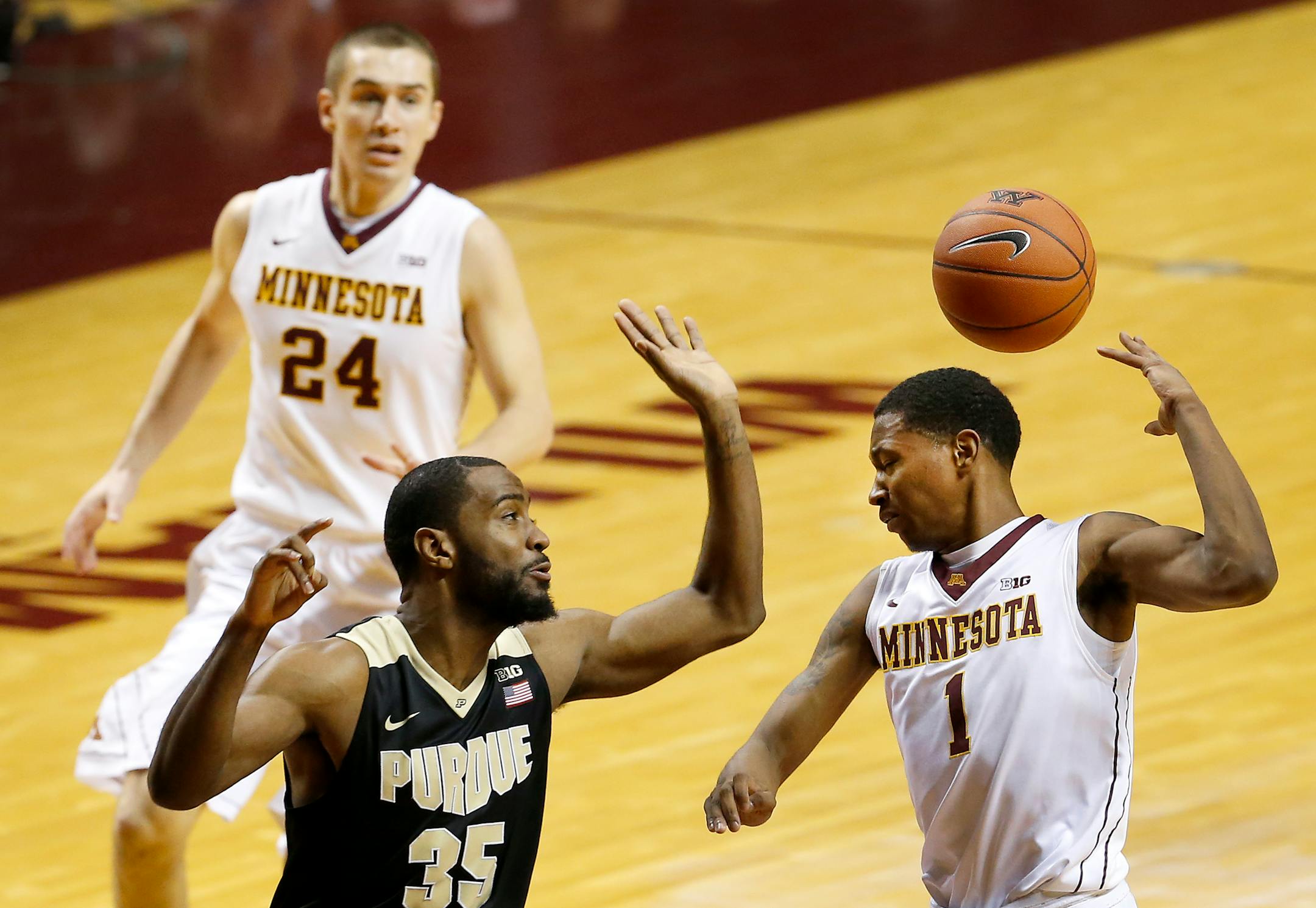 Dupree McBrayer (1) passed the ball to Joey King (24) for an assist while being defended by Rapheal Davis (35) in the first half.