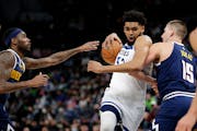 Minnesota Timberwolves center Karl-Anthony Towns (32) drives on Denver Nuggets center Nikola Jokic (15) and forward Will Barton during the first half 