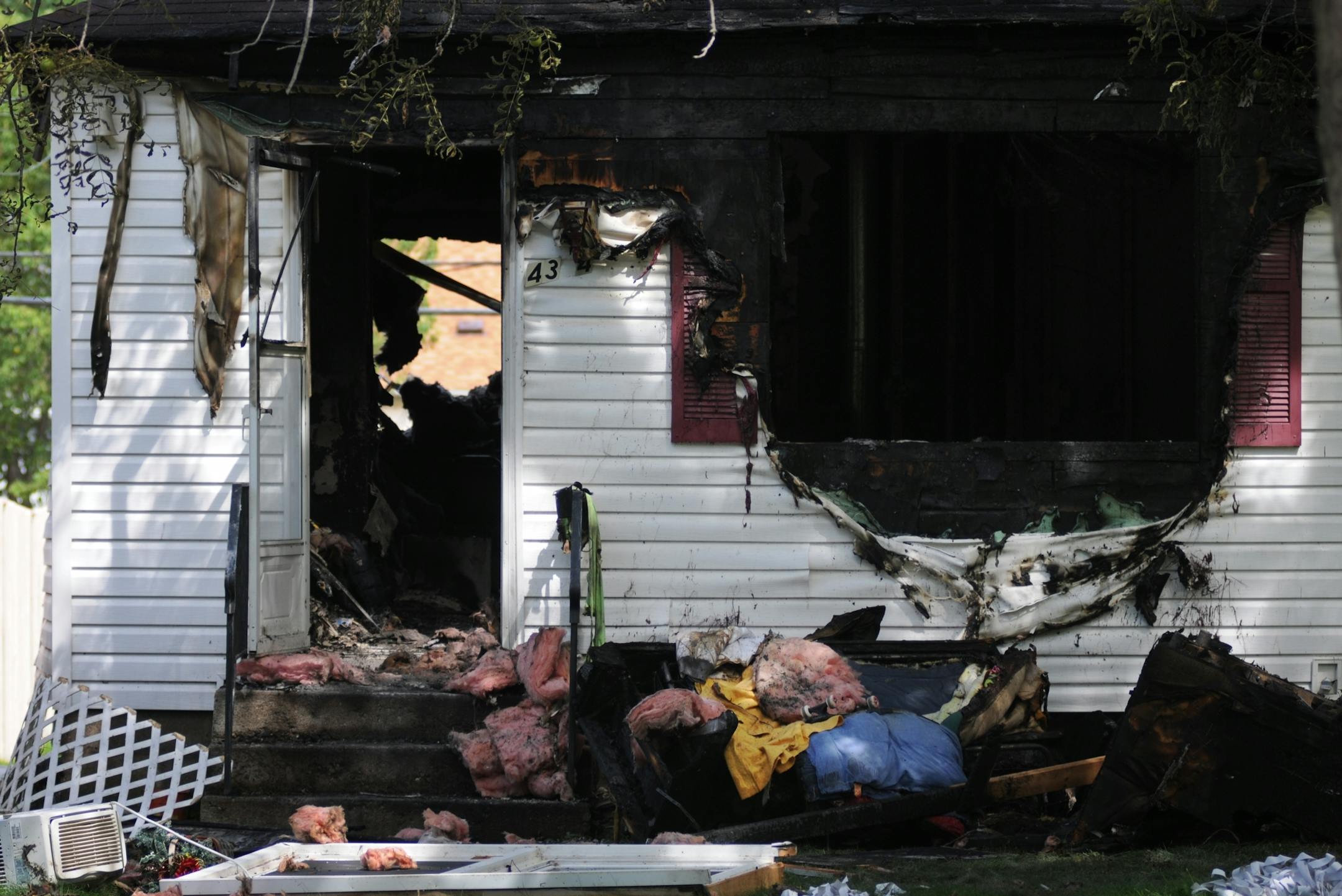 Wreckage could be seen strewn about the yard the site where two people were severely burned after an explosion caused a house fire July 30, 2011 at a small home in North Minneapolis.