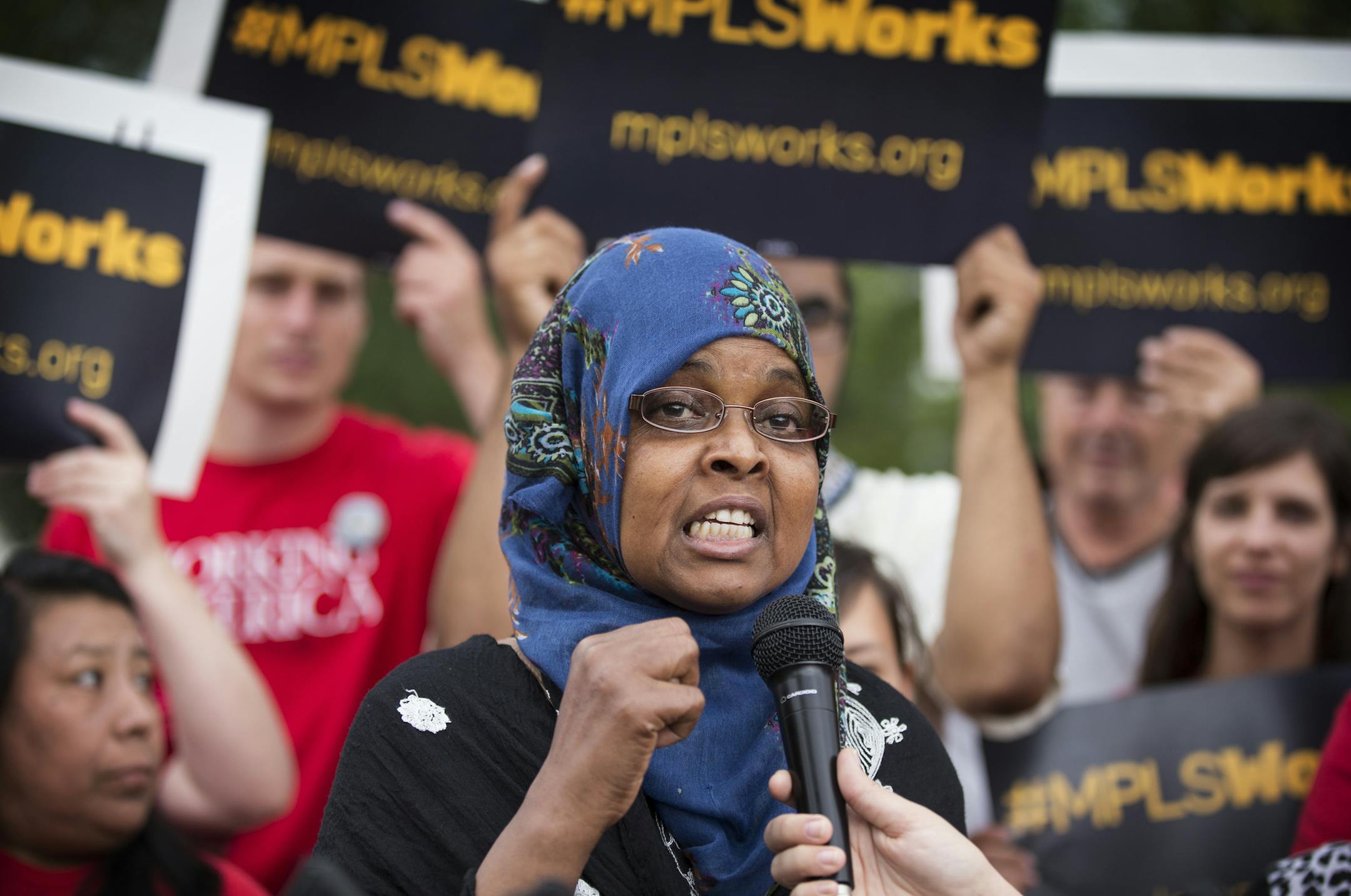 Duniyo Hussein, center, a worker with a local cleaning company, speaks during a rally at a McDonald's on East Lake Street in Minneapolis on Thursday, August 6, 2015. ] LEILA NAVIDI leila.navidi@startribune.com / BACKGROUND INFORMATION: Hourly workers from McDonald&#x2019;s and other employers along with community supporters rallied to highlight the low pay and lack of benefits facing workers in Minneapolis as part of what they called "Minneapolis Works Day."