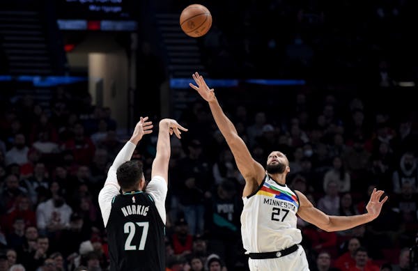 Portland Trail Blazers center Jusuf Nurkic, left, hits a shot over Timberwolves center Rudy Gobert during the first half