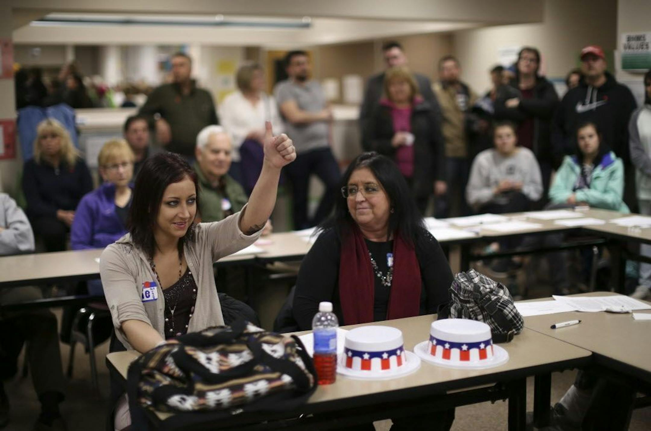 Alexandra Herkal, 27, gave a thumbs up as she spoke in support of Donald Trump at the Burnsville precinct 9 Republican caucus on March 1. A first-time caucus attendee, she brought her mother, Michelle, right.