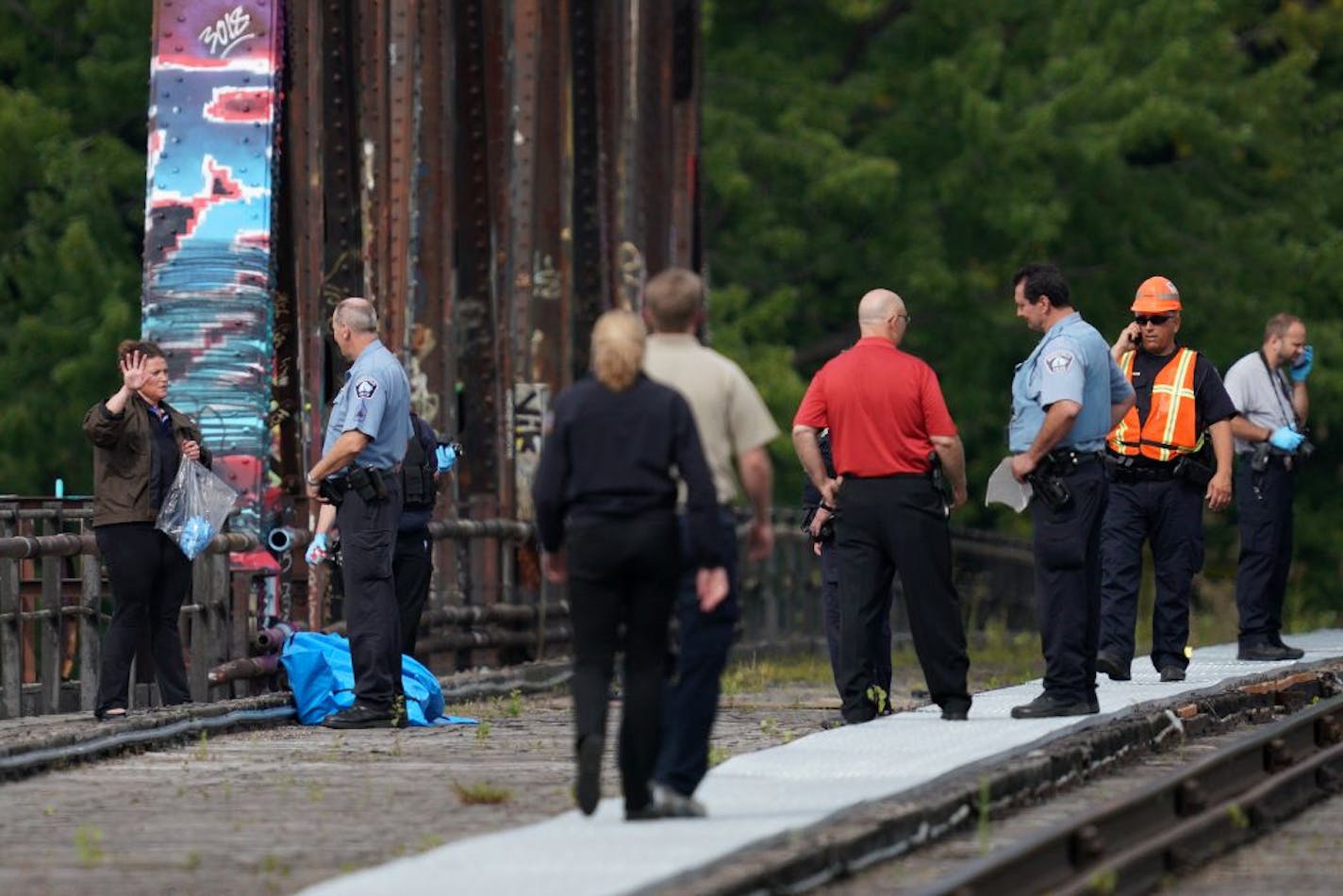 A man's body was covered with a blue tarp as police investigated the scene where he was found dead in the early morning hours Tuesday, Aug. 13, 2019 on the railway tracks near the intersection of 16th Avenue and NE Marshall Street.