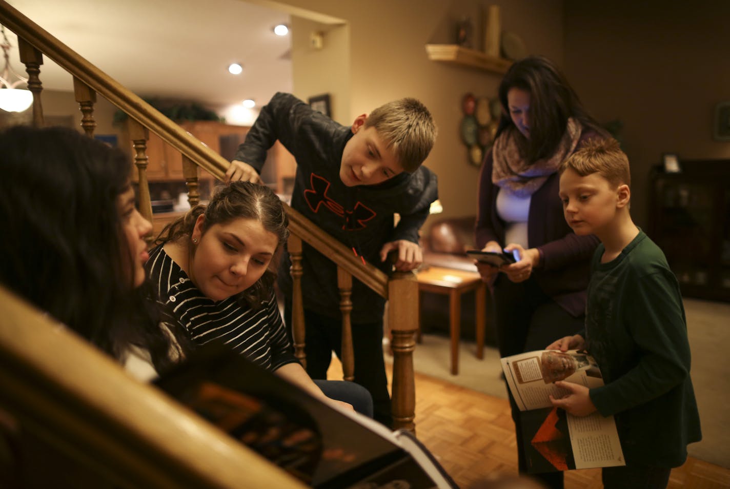 Sam Olson, 13, peeked at the book of awkward family photos that his sisters, Emily, 16, and Ana, 18, were looking at while their mom, Rebecca, tried her hand at a video game he had just been playing. Looking on at right was Jack, 9. ] JEFF WHEELER &#xef; jeff.wheeler@startribune.com The Anoka County city of Blaine is about to eclipse Coon Rapids as the county's largest, but also climbing in terms of income, education and diversity, perhaps signaling the start of a shift for the traditionally blu