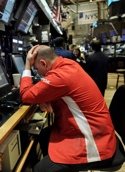A trader holds his head after the closing bell of the New York Stock Exchange, Tuesday, Oct. 7, 2008. The misery worsened on Wall Street Tuesday, with