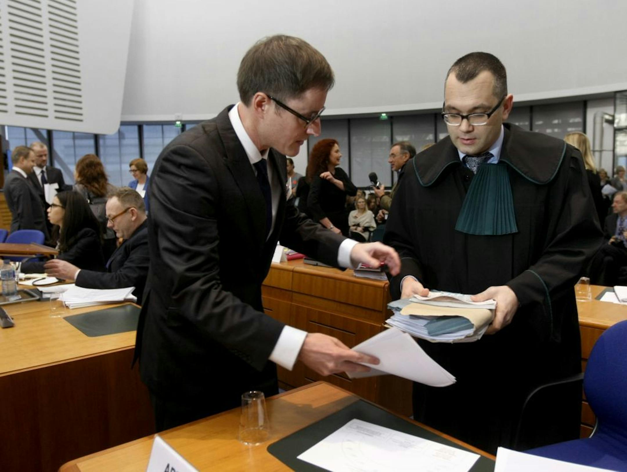 Michael Pietrzak, right, one of the lawyers for Abd al-Rahim al-Nashiri and Abu Zubaydah, is helped by an unidentified assistant as he arrives at the forth section of the European Court of Human Rights in Strasbourg, eastern France, Tuesday, Dec. 3, 2013.