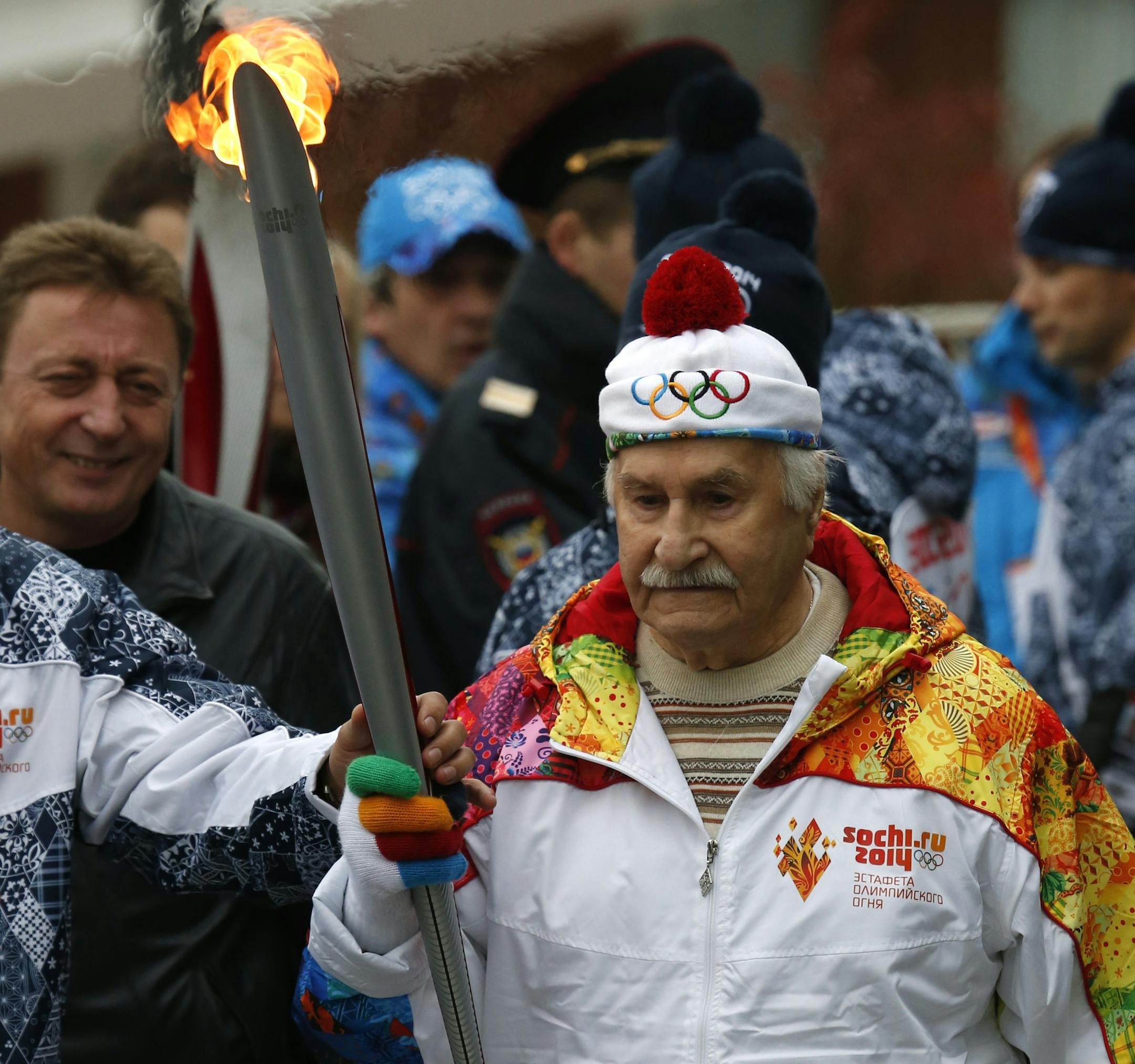Vladimir Zeldin, 98, a Russian theatre and cinema actor holds his torch during a relay in Moscow, Russia, Monday, Oct. 7, 2013. The relay for the Sochi Winter Games, which began Monday in Moscow, will pass through many cities that showcase the historical, cultural and ethnic richness of Russia. (AP Photo/Dmitry Lovetsky)