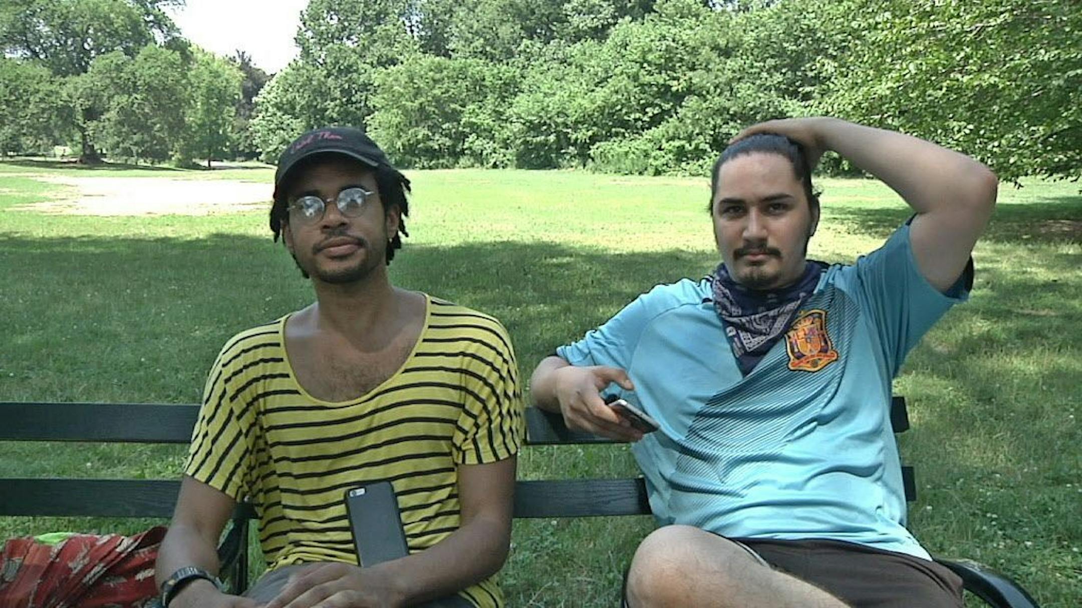 In this July 13, 2016 frame grab from video, Jordan Clark, left, and Lewis Gutierrez sit in Prospect Park as they talk about their new "Pokemon Go" business in the Brooklyn borough of New York. They are among the new entrepreneurs who offer their services as "trainers" for the game at $20 per hour - logging onto a client's "Pokemon Go" account and effectively running up their score while a client is stuck at work or sitting in class.