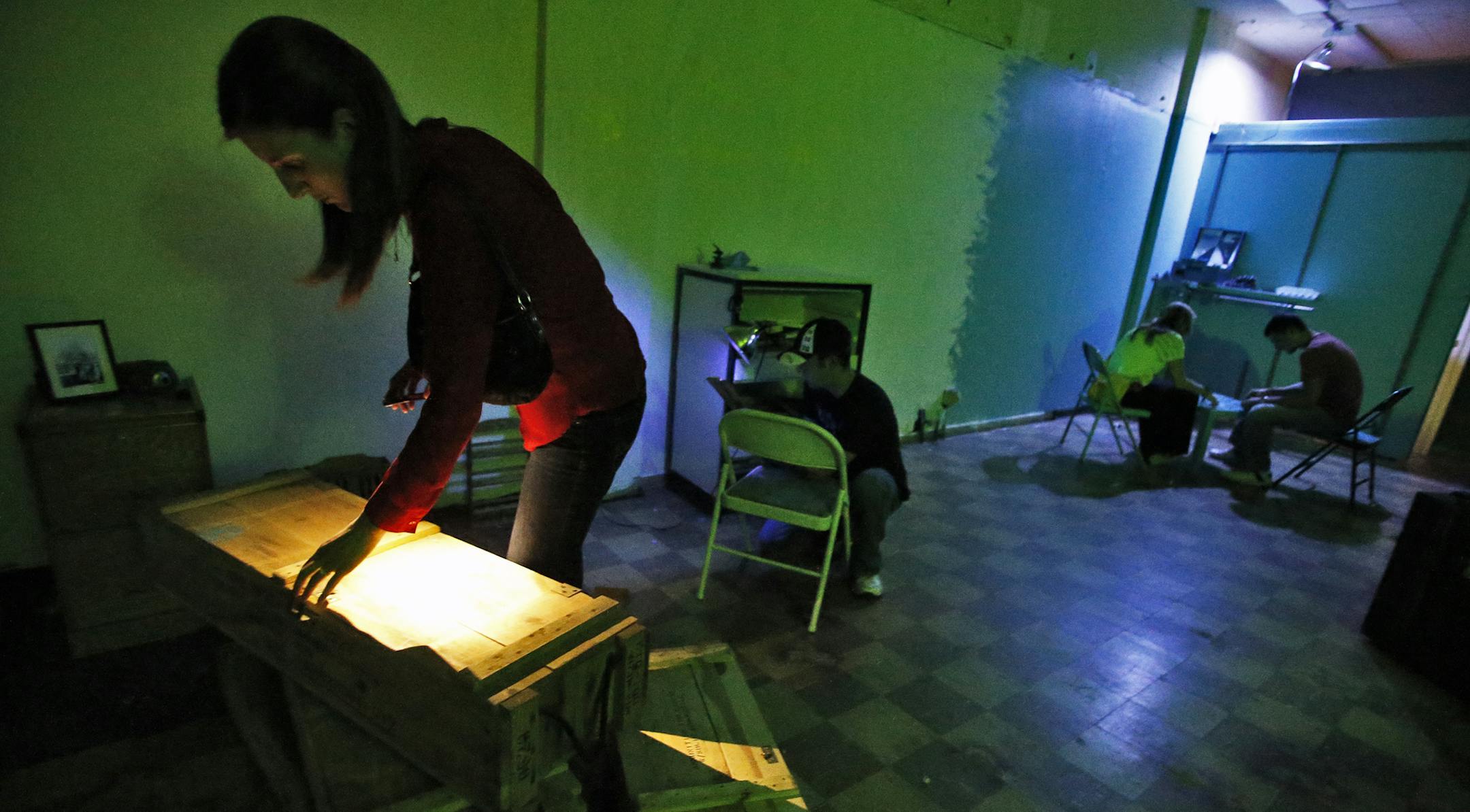 A group works on the various clues presented to them in an effort to find passage out of the riddle room. ] The Riddle Room Bunker in Minneapolis. (MARLIN LEVISON/STARTRIBUNE(mlevison@startribune.com)