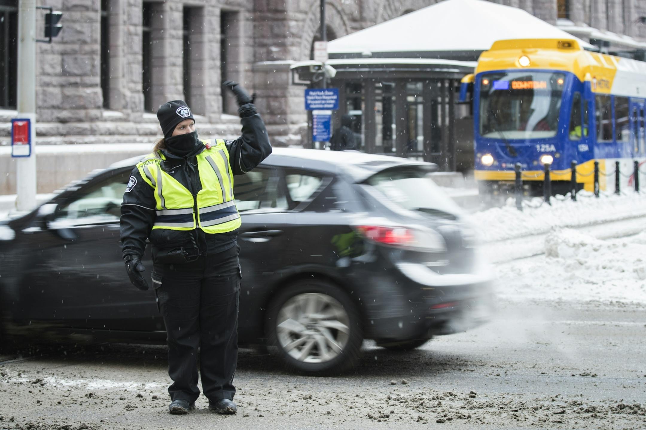 Minneapolis Traffic Control agent Kendra Hackenmueller directs traffic at 5th Street and 3rd Avenue during morning rush hour.