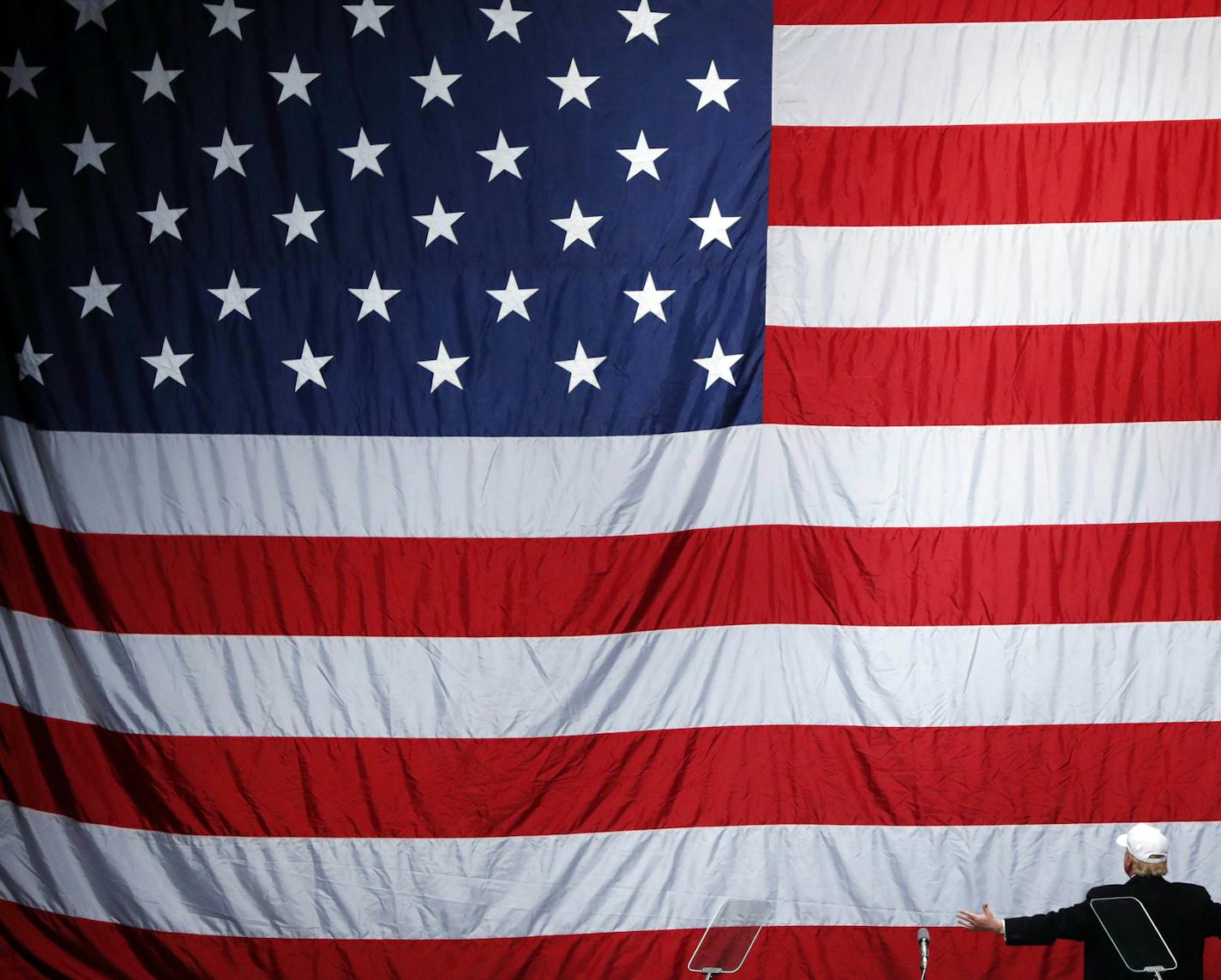 FILE - In this Sunday, Nov. 6, 2016 file photo, Republican presidential candidate Donald Trump turns to face the U.S. flag at a campaign rally in Sterling Heights, Mich. (AP Photo/Paul Sancya)