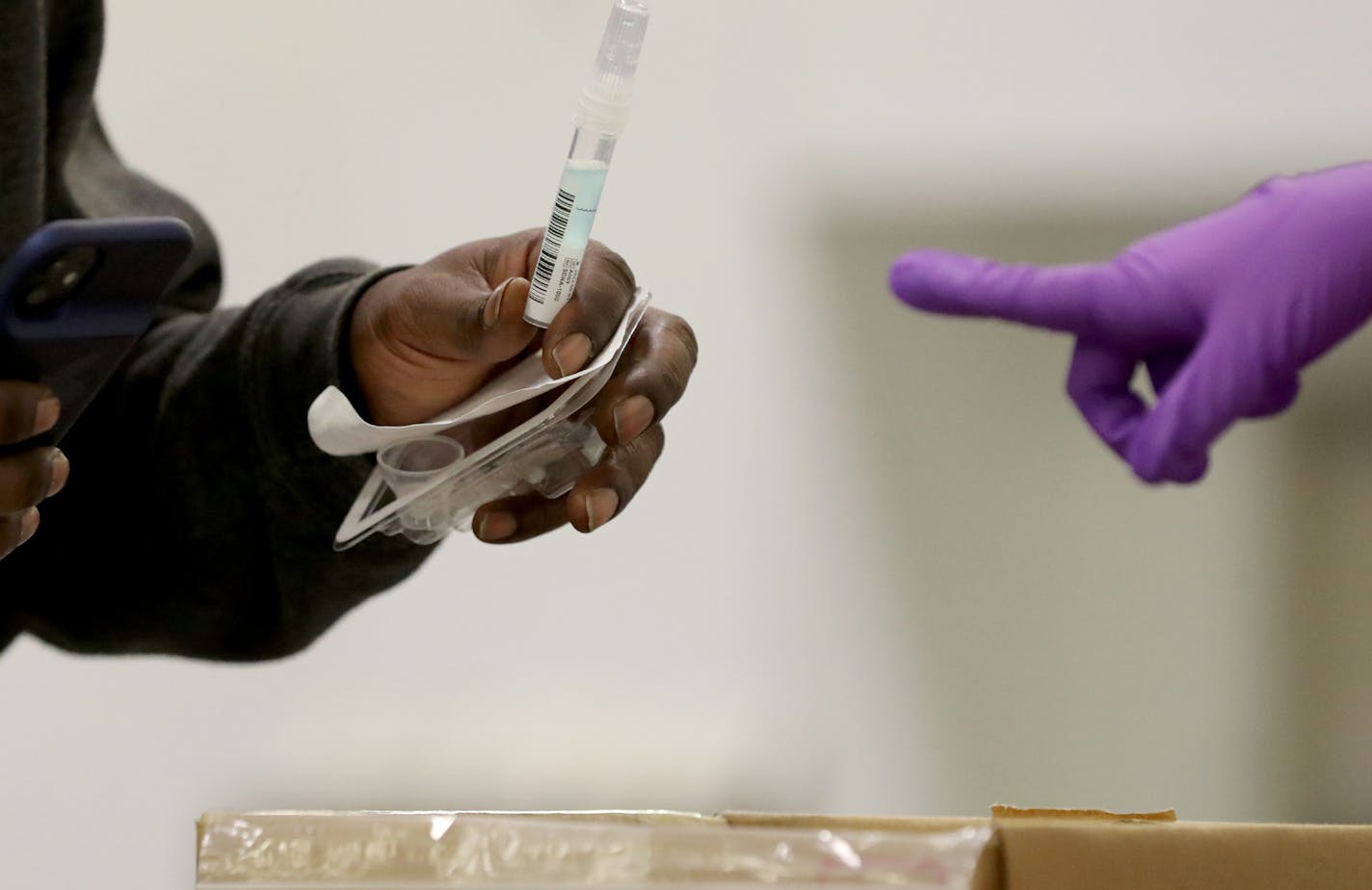 A person at a new saliva testing center for COVID in the Minneapolis Convention Center drops a saliva samples into a collection box Monday in Minneapolis. Yesterday Minnesota reached an all-time high daily COVID count at nearly 6,000 as the U.S. today surpassed 10 million total cases. ] DAVID JOLES • david.joles@startribune.com Monday, Nov. 9, 2020 in Minneapolis, MN new saliva testing center for COVID