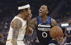 Minnesota Timberwolves guard Jeff Teague, right, drives to the basket as Golden State Warriors guard D'Angelo Russell defends during the first half of
