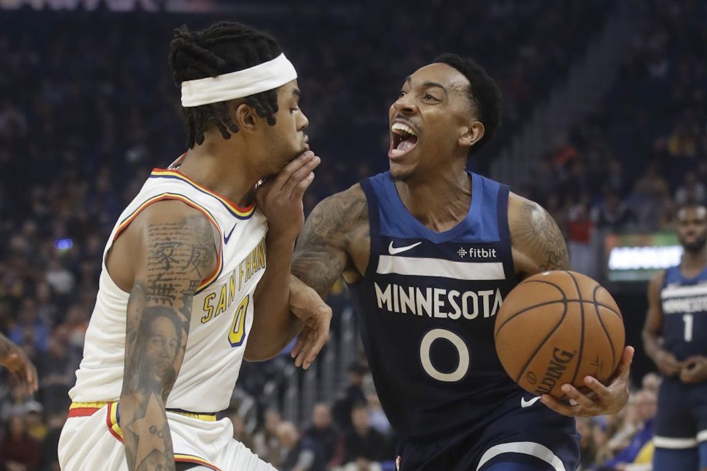 Minnesota Timberwolves guard Jeff Teague, right, drives to the basket as Golden State Warriors guard D'Angelo Russell defends during the first half of an NBA basketball game in San Francisco, Monday, Dec. 23, 2019.