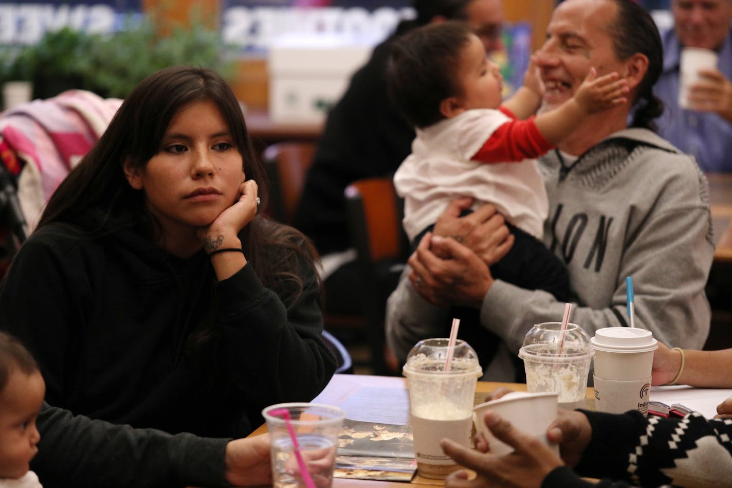 Missy Jackson, left, listened during a Natives Against Heroin meeting as group founder James Cross held her 9-month-old daughter Azariah Thursday. At left is Pixie Eastman with her son Joaz, 6-months.